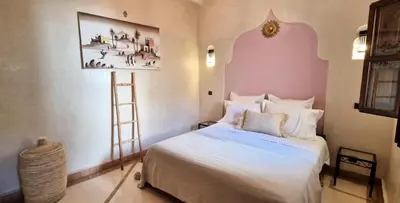 a bedroom with a bed and a painting on the wall at Riad Babmoon - Private Riad with Pool & Rooftop in Marrakech