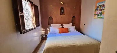 a bedroom with a bed with an orange pillow on it at Riad Babmoon - Private Riad with Pool & Rooftop in Marrakech