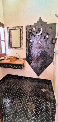 a bathroom with a sink and a mirror at Riad Babmoon - Private Riad with Pool & Rooftop in Marrakech