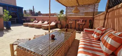 a patio with a bunch of chairs and a table at Riad Babmoon - Private Riad with Pool & Rooftop in Marrakech