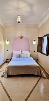 a large bedroom with a large bed with a pink headboard at Riad Babmoon - Private Riad with Pool & Rooftop in Marrakech