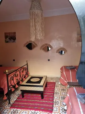 a room with a room with a table and a mirror at Riad Benrahal in Marrakech