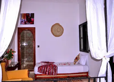 a room with a bed in a room with curtains at Riad Benrahal in Marrakech