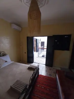 a bedroom with a large bed with a large window at Riad Benrahal in Marrakech