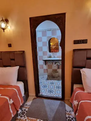 a mirror in a room with a fireplace at Riad Benrahal in Marrakech