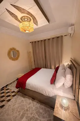 a bedroom with a bed and a chandelier at appartement au cœur du Madina in Marrakech