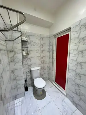 a bathroom with a toilet and a red door at Riad 052 in Marrakech