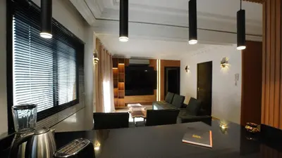 a living room with a table and a couch at Appartement Neuf Carré EDEN in Marrakech