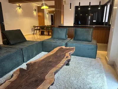 a living room with two couches and a wooden table at Appartement Neuf Carré EDEN in Marrakech