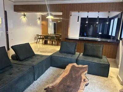 a living room with two couches and a table at Appartement Neuf Carré EDEN in Marrakech