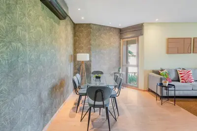 a dining room with a table and chairs and a couch at stylish appart with 3Bedrooms in Prestigia in Marrakech
