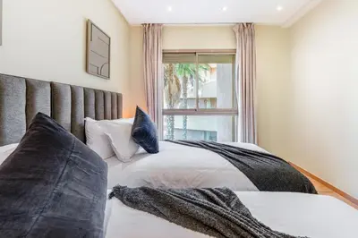 two beds in a room with a window at stylish appart with 3Bedrooms in Prestigia in Marrakech