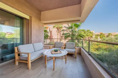 a balcony with a couch and chairs and a table at stylish appart with 3Bedrooms in Prestigia in Marrakech