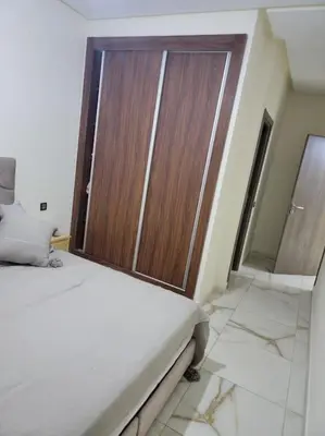 a bedroom with a large wooden door in a room at Magnifique appartement luxueux à 10mn du centre in Marrakech