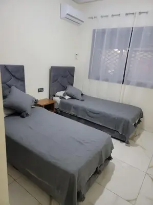 a bedroom with two beds and a window at Magnifique appartement luxueux à 10mn du centre in Marrakech
