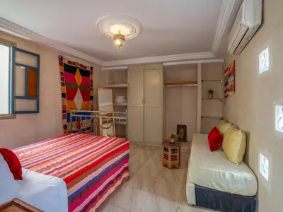 a small bedroom with a bed and a couch at Riad Dar makhzne-location exclusive du Riad entier 4 chambres & terrasse in Marrakech