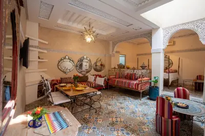 a living room with red couches and a table at Riad Dar makhzne-location exclusive du Riad entier 4 chambres & terrasse in Marrakech