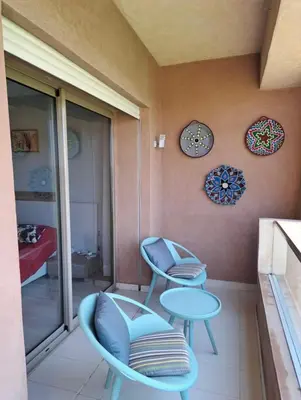 a room with two chairs and a table and clocks at Luxury 2 bedroom flat Center Marrakesh in Marrakech