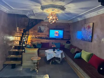 a room with a couch and a table and a tv at riad didimora in Marrakech