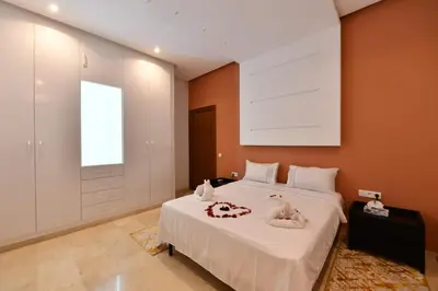 a bedroom with a large white bed with orange walls at villa noria golf 4 chambres centre ville in Marrakech