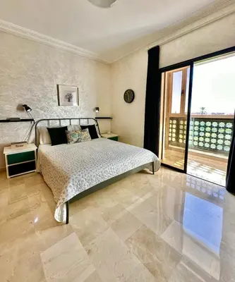 a bedroom with a bed and a large window at Hosted by Zakia in Marrakech