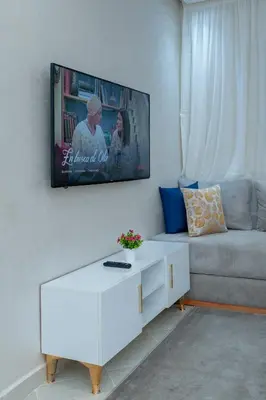a living room with a couch and a tv on the wall at New elegant apartment with 2 bedroom in Marrakech