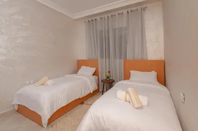 two beds in a room with white sheets at New elegant apartment with 2 bedroom in Marrakech