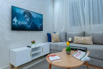 a living room with a couch and a tv on the wall at New elegant apartment with 2 bedroom in Marrakech