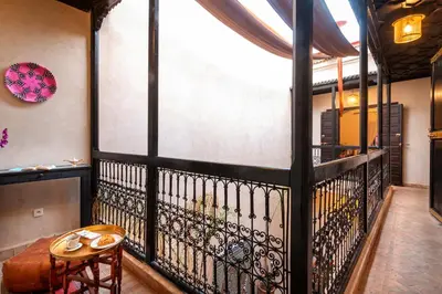 a room with a balcony with a table and chairs at Riad Dar Haris in Marrakech