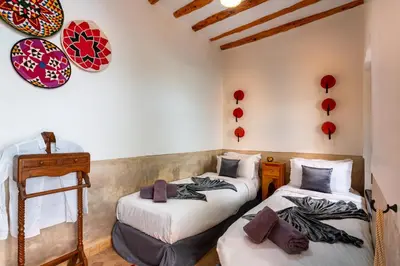 two beds in a room with red decorations on the wall at Riad Dar Haris in Marrakech