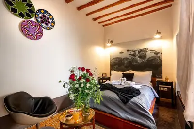 a bedroom with a bed and a table with a vase of flowers at Riad Dar Haris in Marrakech