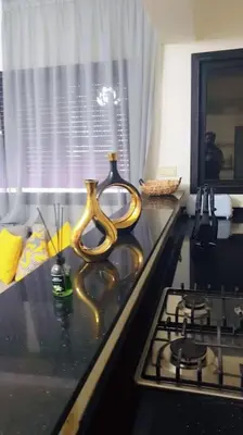 a kitchen counter with two vases on top of a stove at Appartement familial de luxe in Marrakech