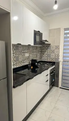 a kitchen with white cabinets and a microwave at Lyana Home in Marrakech