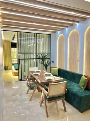 a living room with a table and a green couch at Appartement Marrakech Hivernage N4 RESIDENCE CAPRICE PALACE in Marrakech