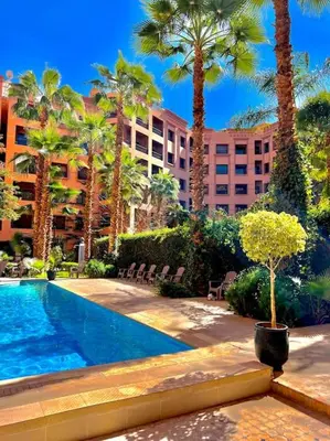 a resort with a pool and palm trees and a building at Appartement Marrakech Hivernage N4 RESIDENCE CAPRICE PALACE in Marrakech