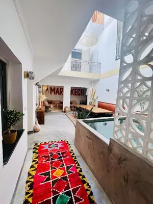 a large room with a pool and a rug on the floor at Votre riad privé en médina avec services inclus in Marrakech