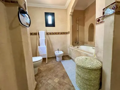 a bathroom with a toilet and a tub and a sink at Villa Camélia des 3 Z in Marrakech