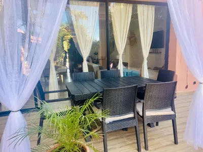 a dining room table with chairs and curtains at Villa Camélia des 3 Z in Marrakech