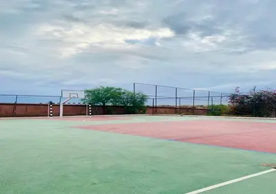 an empty court with a basketball hoop on a tennis court at Villa Camélia des 3 Z in Marrakech