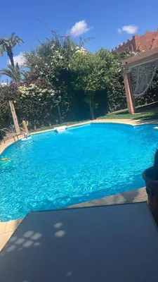 a large blue swimming pool in a yard at Villa Camélia des 3 Z in Marrakech