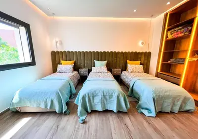 a room with three beds in a room at Villa de luxe, Piscine chauffée, Petit Déjeuner, Hammam, Ménage, Proche centre de Marrakech in Marrakech