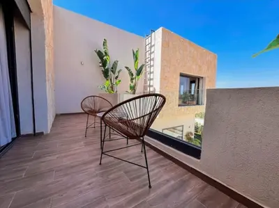 two chairs on the balcony of a building at Villa de luxe, Piscine chauffée, Petit Déjeuner, Hammam, Ménage, Proche centre de Marrakech in Marrakech
