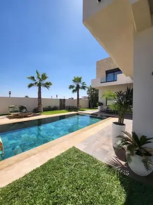 a swimming pool in a house with palm trees at Villa de luxe, Piscine chauffée, Petit Déjeuner, Hammam, Ménage, Proche centre de Marrakech in Marrakech