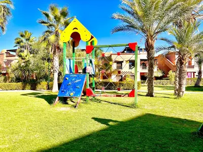 a playground in a park with palm trees at Garden Villa-Style Retreat with Patio, BBQ & Pools in Marrakech