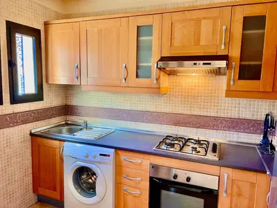 a kitchen with a stove and a washing machine at Garden Villa-Style Retreat with Patio, BBQ & Pools in Marrakech