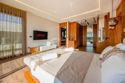 a bedroom with two beds and a tv on the wall at Villa Talia, Luxury Stay, Golf & Lake View in Marrakech