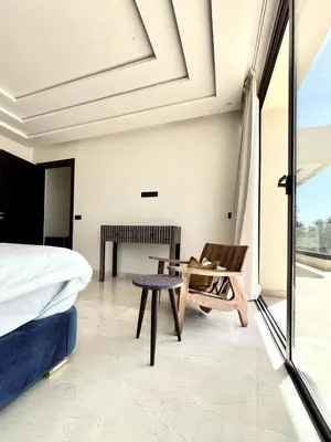 a bedroom with a bed and a chair and a table at villa white in Marrakech
