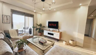 a living room with a couch and a tv at Apartment Coralia - Pool - Terrace in Marrakech