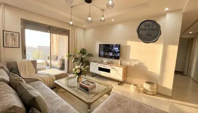 a living room with a couch and a tv at Apartment Coralia - Pool - Terrace in Marrakech