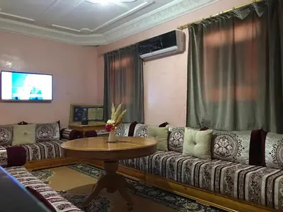 a living room with couches and a table and a television at DaR CHAMSS in Marrakech